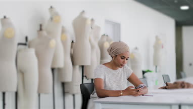 Muslim designer looking at smartphone