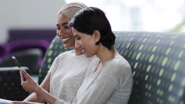 Muslim friends looking at smartphone