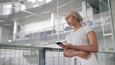 Muslim businesswoman using a smartphone in an office