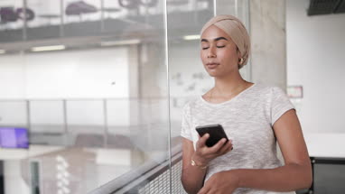 Muslim businesswoman using a smartphone in an office