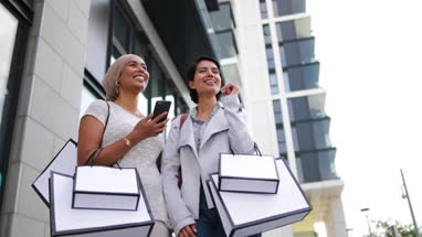 Muslim friends using a smartphone on a shopping trip