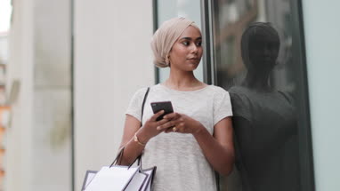 Muslim woman using a smartphone on a shopping trip