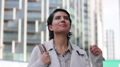 Arabic businesswoman looking up at modern city