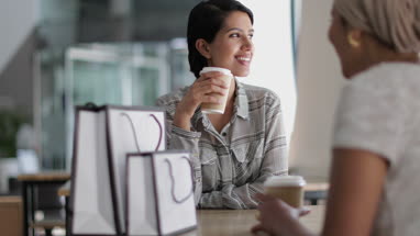 Female Muslim friends having coffee together in a shopping mall