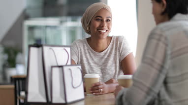 Female Muslim friends having coffee together in a shopping mall