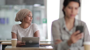 Muslim businesswoman looking out of the window of a cafe