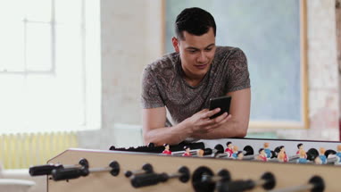 Young adult male using smartphone in a creative office