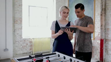 Young adults using digital tablet in a creative office
