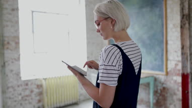 Young adult female using digital tablet in a creative office