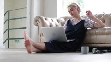 Millennial using laptop in a loft apartment