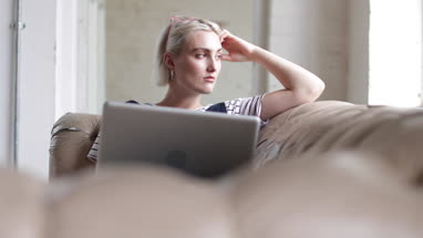 Millennial using laptop in a loft apartment