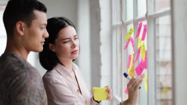 Young adults planning in a creative office with adhesive notes
