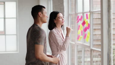Young adults brainstorming in a creative office with adhesive notes