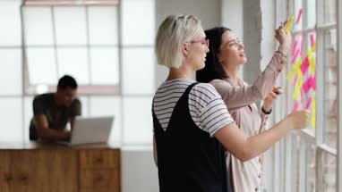 Young adults planning in a creative office with adhesive notes