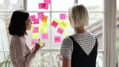 Young adults brainstorming in a creative office with adhesive notes