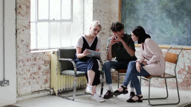 Young adults in a meeting in a creative studio with a digital tablet