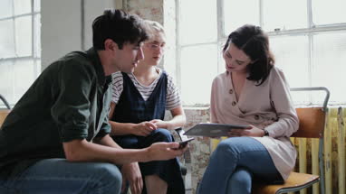 Young adults in a meeting in a creative studio with a digital tablet