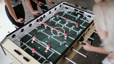 Friends scoring goal on table football