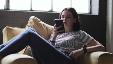 Millennial using smartphone in a loft apartment