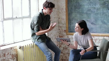Young adults in a meeting in a creative studio with a digital tablet