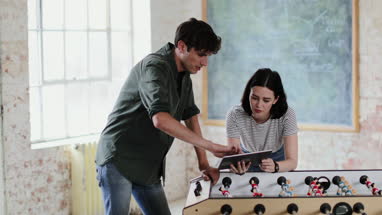 Young adults in a meeting in a creative studio with a digital tablet