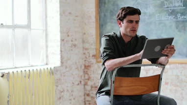 Young adult male using digital tablet in a creative office