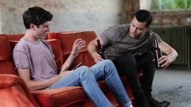 Millennials using smartphones relaxing on sofa