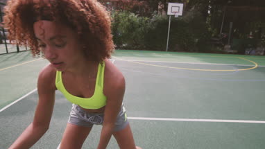 Young adult female playing basketball