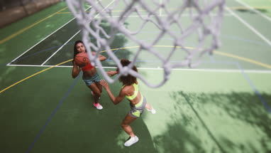 Overhead shot of young adult female basketball player scoring a hoop
