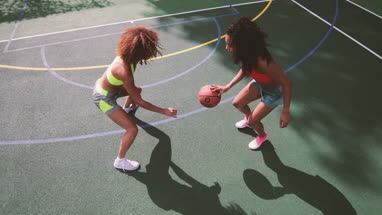 Overhead shot of young adult females playing basketball