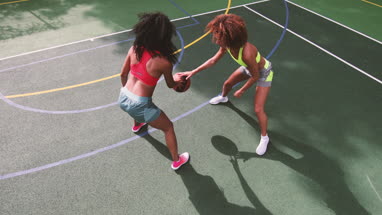 Overhead shot of young adult females playing basketball
