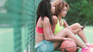 Friends taking a break from training on a basketball court