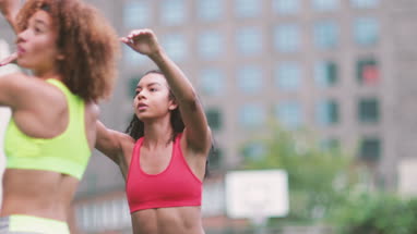 Young adult females playing basketball