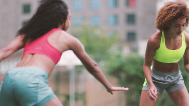 Young adult females playing basketball