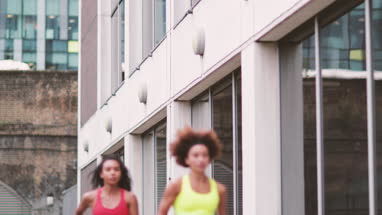 Young adult females running in urban city