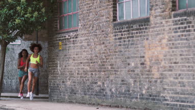 Young adult females running in urban city