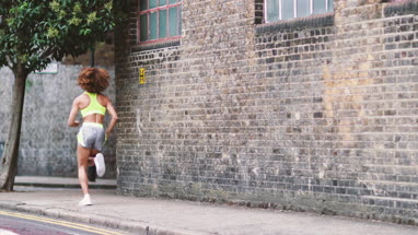 Young adult female running in urban city