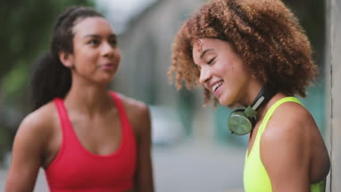 Young adult females taking a break on a run in urban city