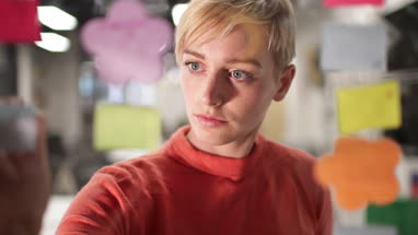 Young adult female brainstorming ideas at night in an office