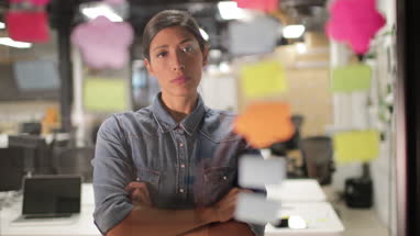 Adult female brainstorming ideas at night in an office