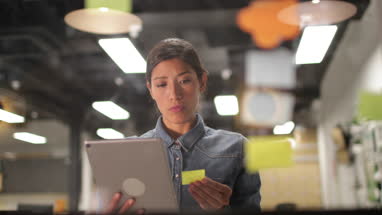 Adult female brainstorming ideas at night in an office