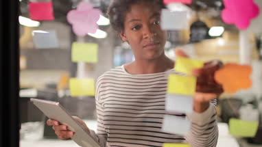 African American female brainstorming ideas at night in an office