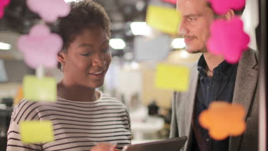 Coworkers working late meeting using stickynotes