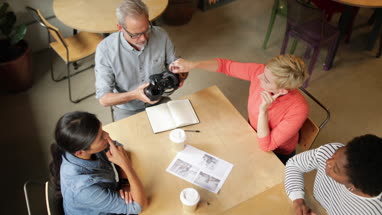 Overhead shot of coworkers discussing VR headset technology
