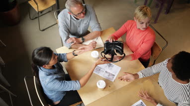 Overhead shot of coworkers discussing VR headset technology