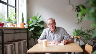 Portrait of mature businessman working in a cafe