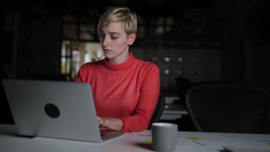 Young adult female working late in an office