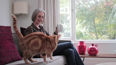 Mature adult female relaxing at home with a cat