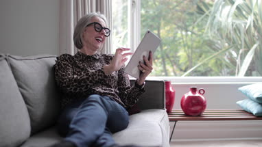 Mature adult female laughing with a digital tablet