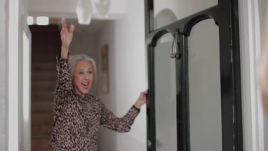 Grandmother opening door to visiting family